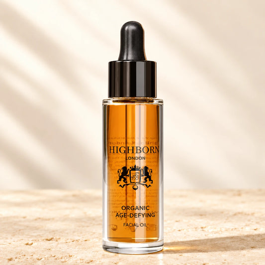 Organic Age-Defying Facial Oil 30ml dropper bottle on warm ivory stone — styled product image